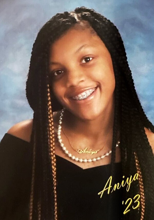 A young lady posing for her senior portrait and smiling.